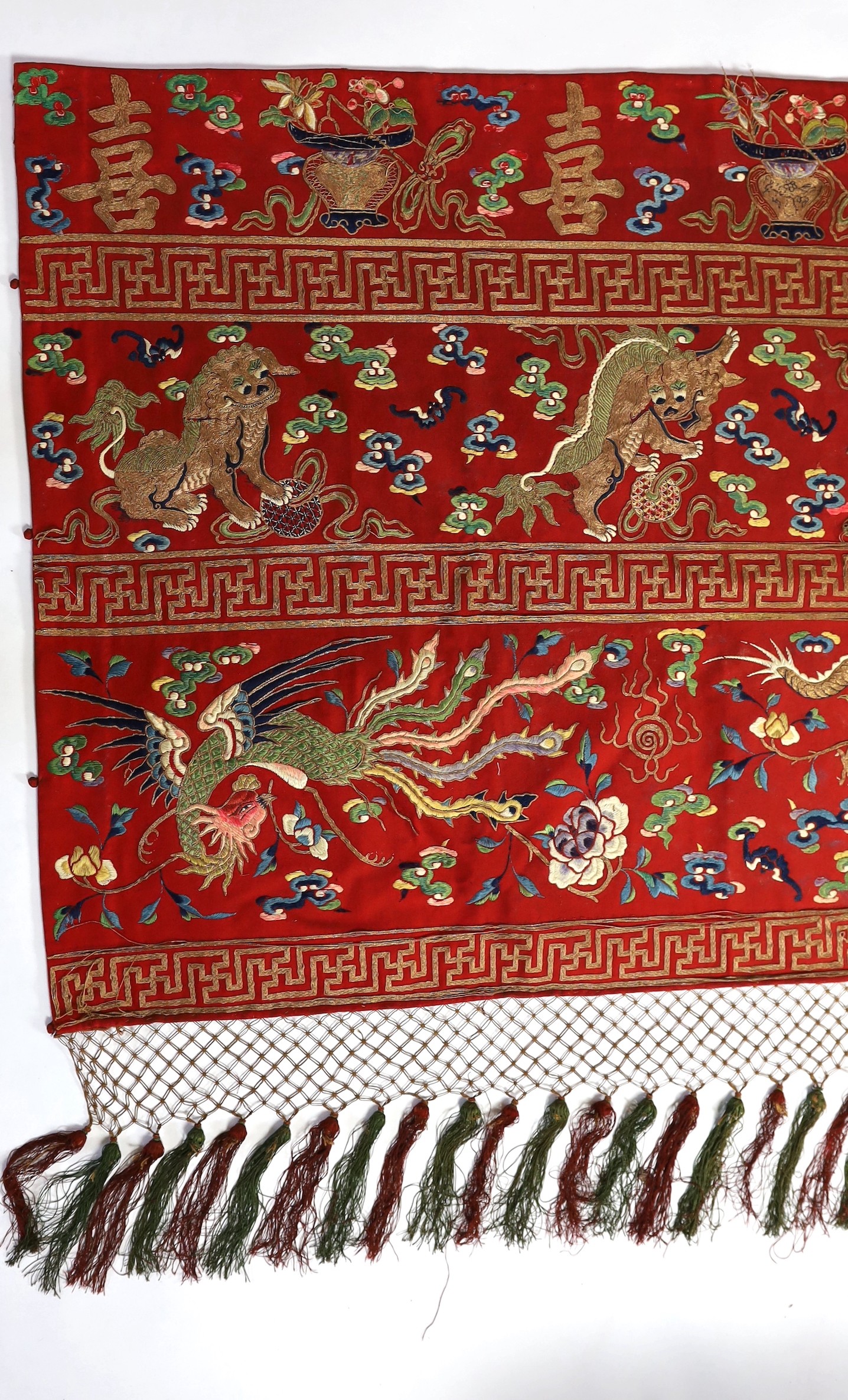 A Chinese embroidered silk ‘dragon, phoenix and lion’ panel or table frontal, late Qing dynasty, 117cm x 337cm